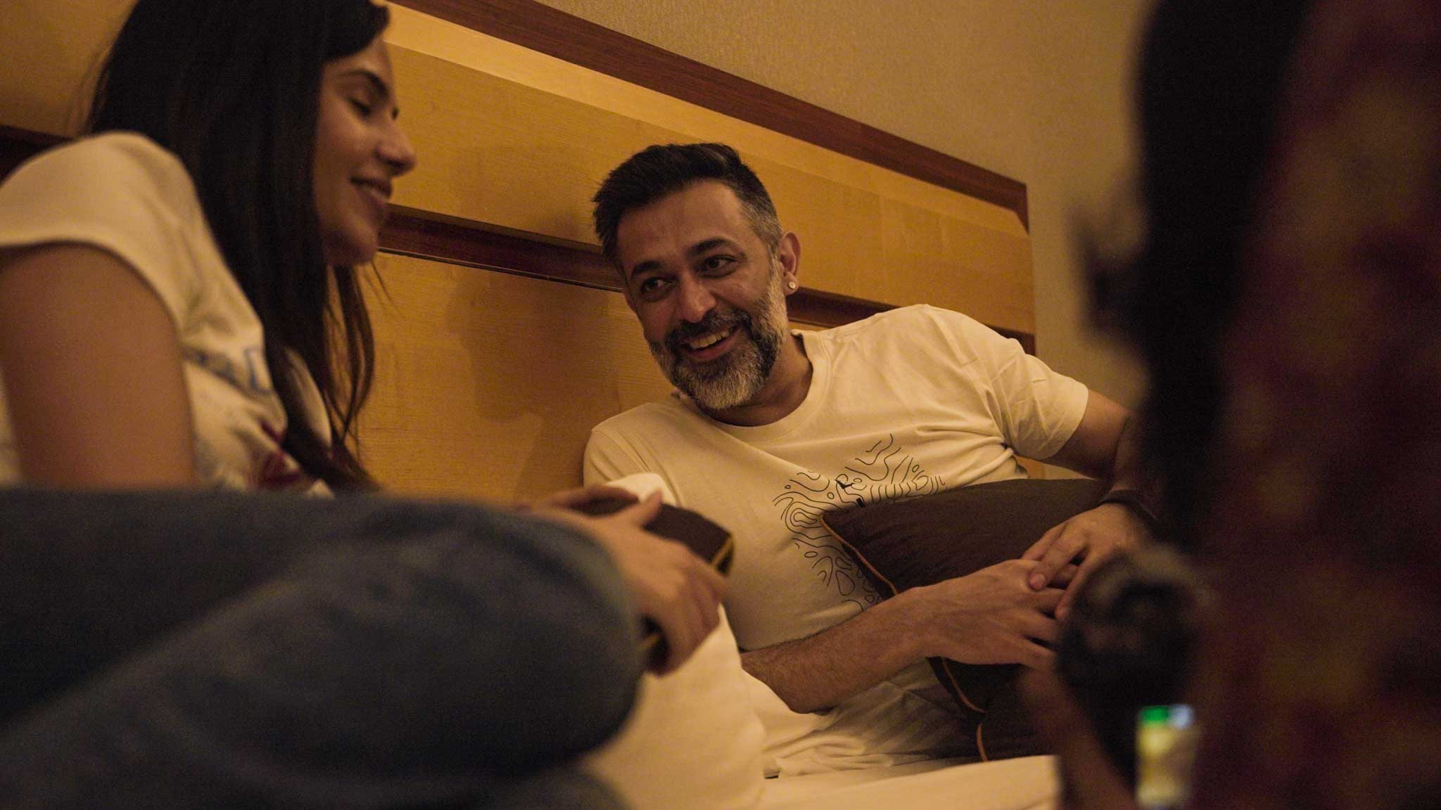 Couple laughing and chatting indoors on comfortable lounge during Bengaluru’s Best Playcation.